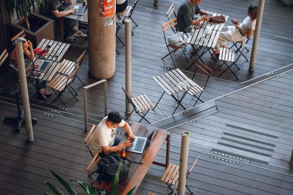 People working on laptops at outdoor café tables in Bangkok