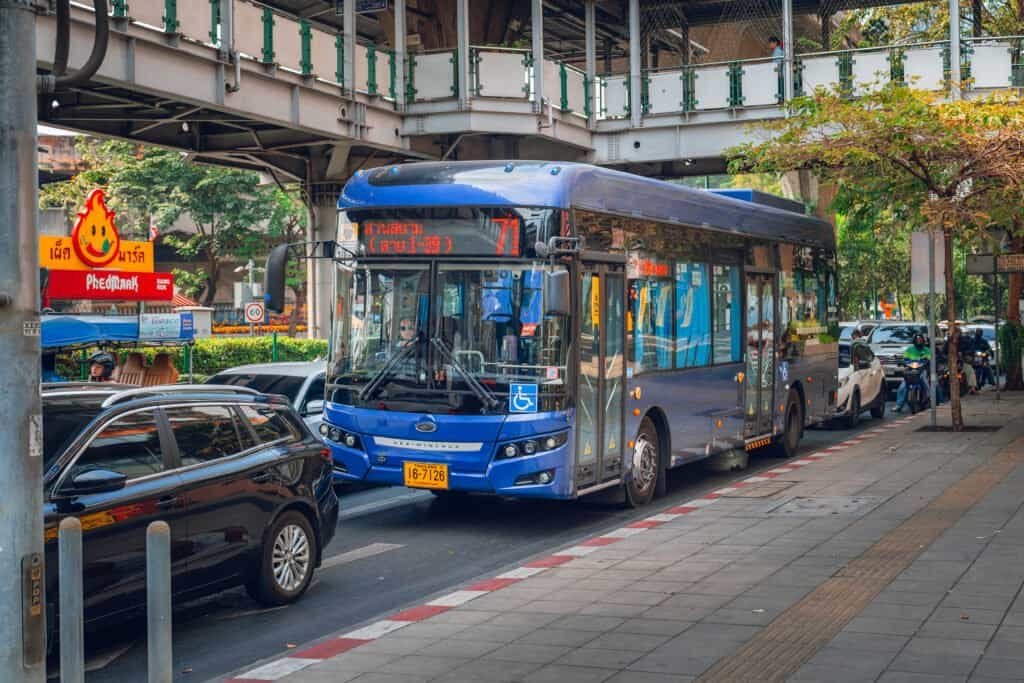 Blue city bus stopped on a Bangkok street