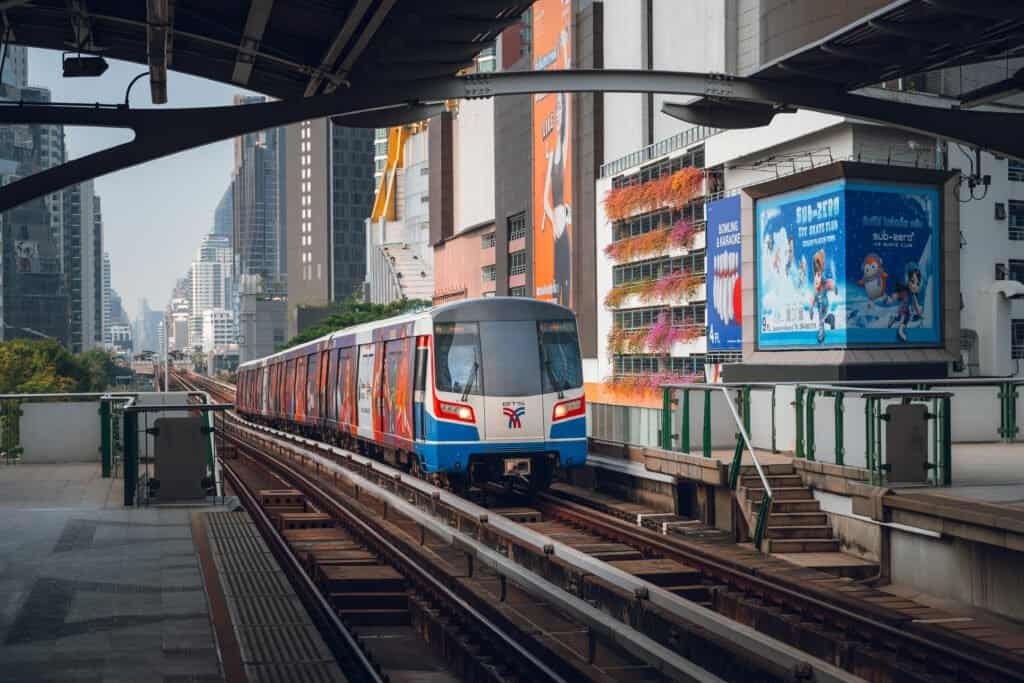 BTS Skytrain traveling through an elevated station in Bangkok