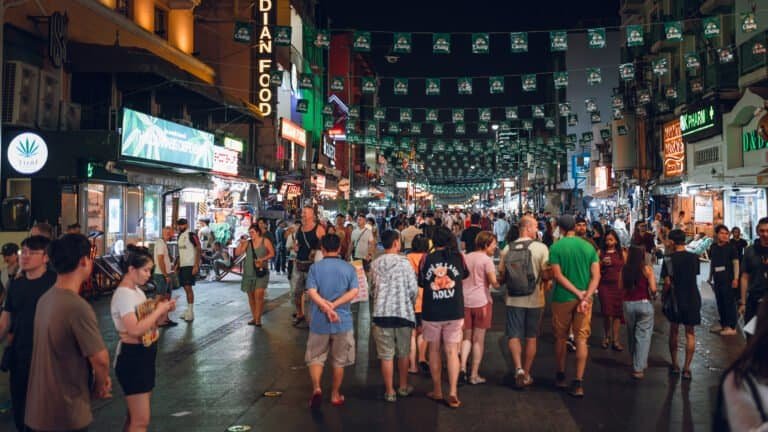 Wide view of Khaosan Road at night with crowds and neon signs