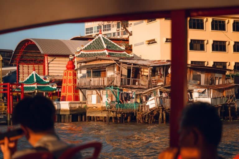 Riverside houses and a small shrine along the Chao Phraya River in Bangkok