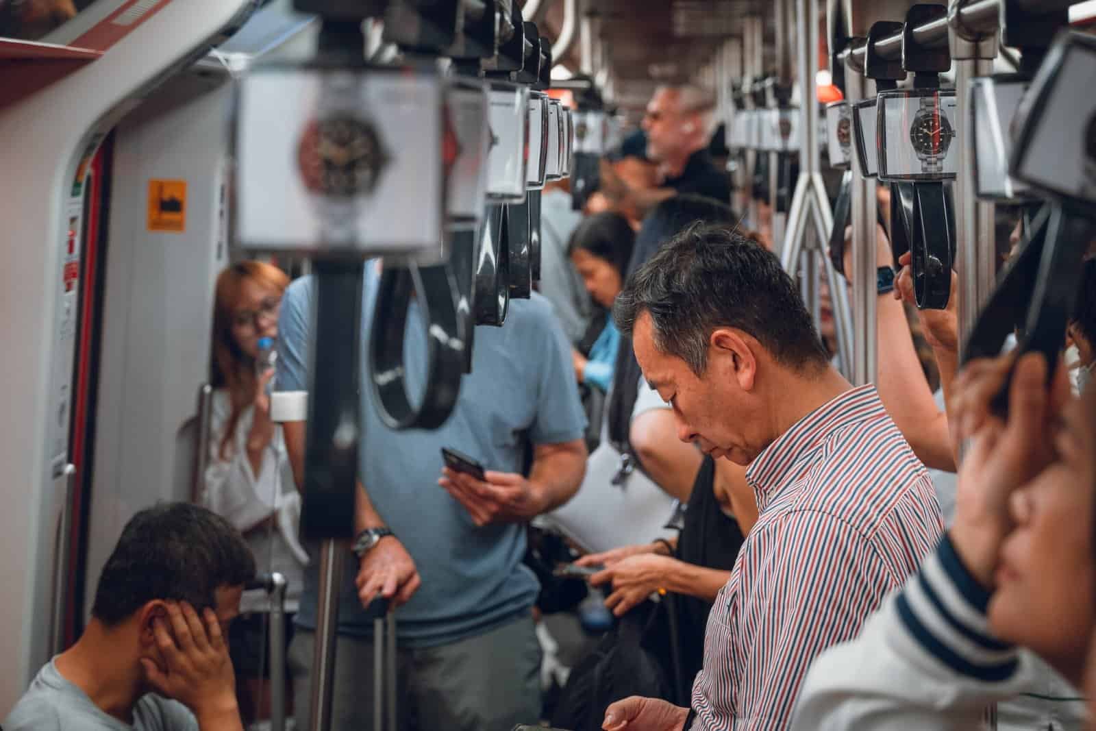 Passengers standing inside a crowded Bangkok train carriage
