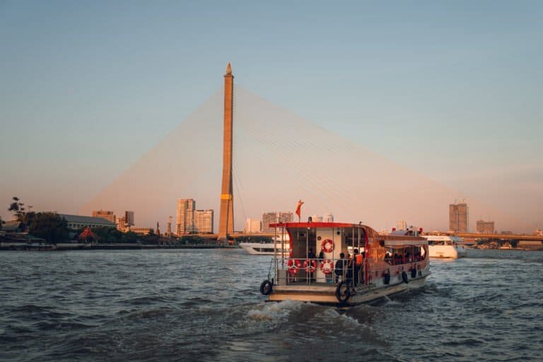 River boat passing Rama VIII Bridge on the Chao Phraya River in Bangkok